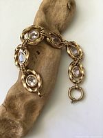 Full view of gold-tone panel bracelet draped on wood prop