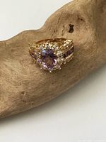 Front view of gold vermeil ring showing oval amethyst glass center, crystal halo, and shoulder details