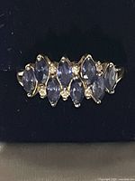 Front view of ring showing marquise tanzanite stones and clear accents