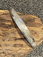 Top view of engraved sterling silver bangle on wood background