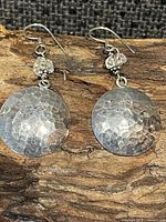 Front view of both disc earrings on wood surface