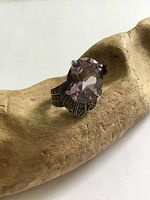 Front view showing large oval amethyst glass stone and marcasite detailing