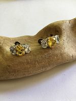 Front view of earrings showing yellow and clear stones