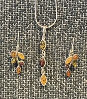 Pendant and both earrings shown together on display fabric