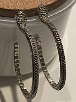 Full view of both snake hoop earrings hanging, showing pavé marcasite detailing