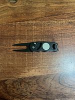 Divot tool open showing two prongs and ball marker