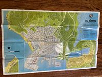 Wide shot of unfolded Los Santos GTA V map on wooden surface