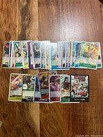 Spread of roughly 30 One Piece trading cards displayed on wood surface