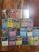 Spread of about 22 Pokémon cards showing mix of languages, foils and standard prints