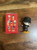 Jung Kook figurine beside illustrated box