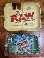 Top view of both metal rolling trays, RAW branded tray and sealed cartoon tray