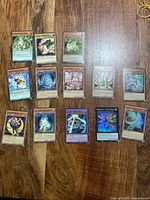All thirteen Yu-Gi-Oh! cards spread on wooden surface
