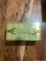 Top view of gold embossed Yu-Gi-Oh! trading card tin