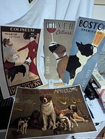 Four dog-themed repro advertisement prints arranged leaning against wall, visible from front.