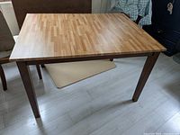 Full view of the solid wood kitchen table with butcher block style top, showing its rectangular shape and cherry red solid legs.
