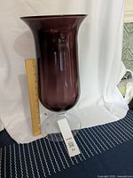 Full view of tall cherry black glass vase with ruler alongside showing height approximately 18 inches.