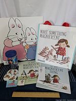 Framed Max and Ruby art with two children's books, Make Something Magnificent tote bag, and Nelvana drink cup in the background