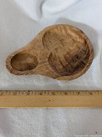 Close-up top view of the small wooden bowl showing natural wood grain and two compartments, approximately 7 inches long.