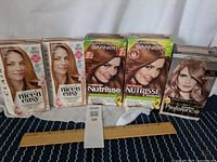 Five unopened boxes of hair colour, various shades of red and auburn. Brands include Clairol Nice'n Easy, Garnier Nutrisse Cream, L'Oreal Preference.