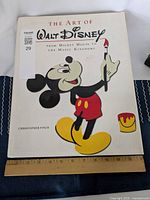 Front cover of the book featuring Mickey Mouse holding a paintbrush and paint can, title and author visible.
