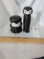 Two vampire-themed garlic tools with vampire faces and black cloak designs shown with measurement ruler below for scale.