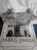 Fabris Venezia brand bag with the grey shawl inside, showing the brand and contact info.