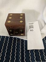 Large carved wooden die shaped box with gold inlays and numbered sides visible.