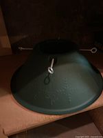 Green plastic Christmas tree stand with metal screws for securing tree trunk