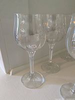 Close-up of two crystal stemware glasses showing rounded bowls, narrow stems, and clear transparent crystal material.