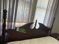 Full view of the wooden headboard with decorative carved elements and turned posts.