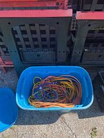 Photo of blue plastic tub containing extension cords and bungee cords in multiple colors.