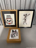 Three pieces of Indigenous-style artwork signed by Wp, including two framed prints and one wood-mounted panel, displayed side by side.