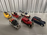 Photo showing all six die cast vintage toy vehicles including fire truck, tow truck, delivery van, and other classic cars on a flat surface.