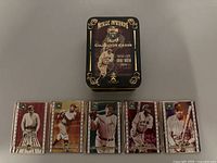 Collector cards laid out with the accompanying black metallic tin labeled 'Metallic Impressions Babe Ruth Collector Cards'. Cards depict Babe Ruth in various poses and vintage baseball uniforms.