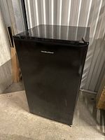 Full view of the closed black Hamilton Beach mini fridge showing the exterior and door handle.
