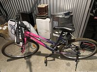 Full view of Ridge Runner mountain bike with pink and purple frame, front and rear wheels, pedals, and saddle visible.