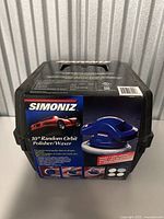 Closed black hard carrying case with Simoniz logo and product label showing the blue polisher and details, standing upright.