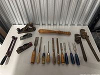Full overview of the tool set including hand planes, chisels, pipe wrenches, and a hacksaw.