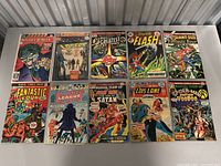 Photo showing 10 vintage comic books arranged in two rows of five, featuring Marvel and DC titles.