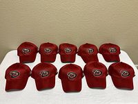Ten red Arizona Diamondbacks hats laid out front view