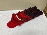 Stack of red and maroon visors showing quantity and colors
