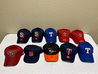 All ten caps arranged in two rows showing team logos and colours