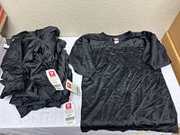 Stack and single display of black Wilson jerseys with tags visible