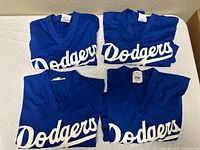 Four folded blue Dodgers jerseys front view