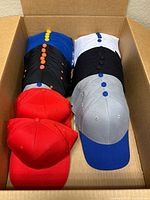 Box view showing six stacks of blank caps in assorted colours