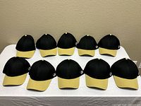 all ten black and yellow caps displayed top front