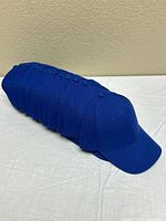 Stack of ten identical blue caps