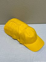 Stack of ten identical yellow caps