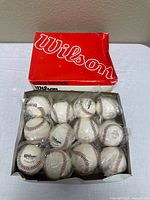 Open box showing 12 individually bagged Wilson baseballs