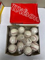 Open Wilson box showing twelve individually wrapped baseballs